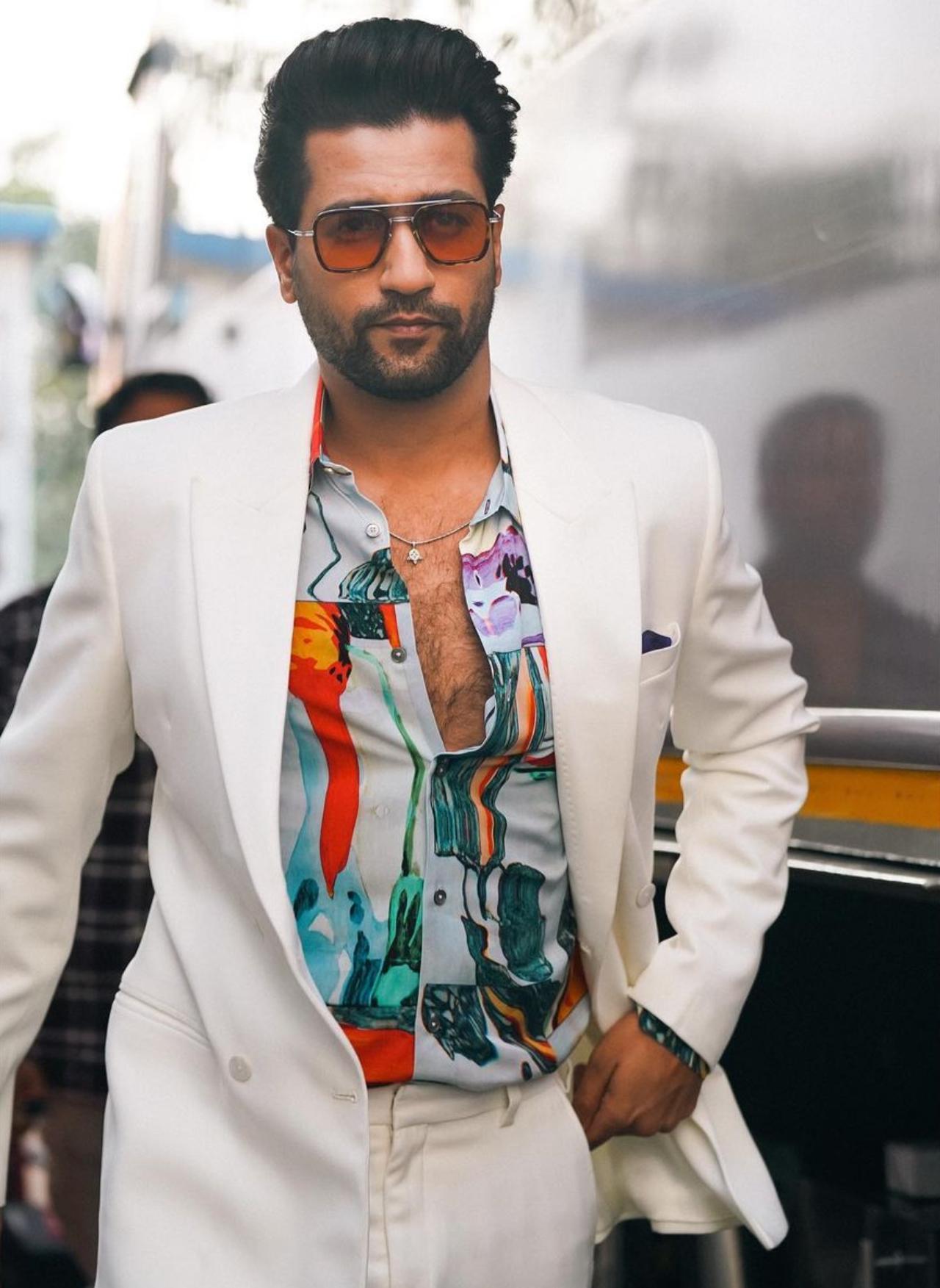 The actor who always brings something new to the table for his audience, Vicky is one of the sought after stars who loves to play with colours and prints. From comfy co-ord suit sets to chic tuxedos, Vicky Kaushal's fashion sense proves that he loves to suit up. During the promotions of his newly released movie, 'Govind Naam Mera', the actor was seen sporting an all-white blazer looking handsome as hell. He paired his white blazer with a multi-coloured shirt which had abstract prints all over. While his colourful shirt underneath added flamboyance to his overall outfit, his tinted shades made him look more appealing. Also, don't forget his cute little silver neckpiece!  